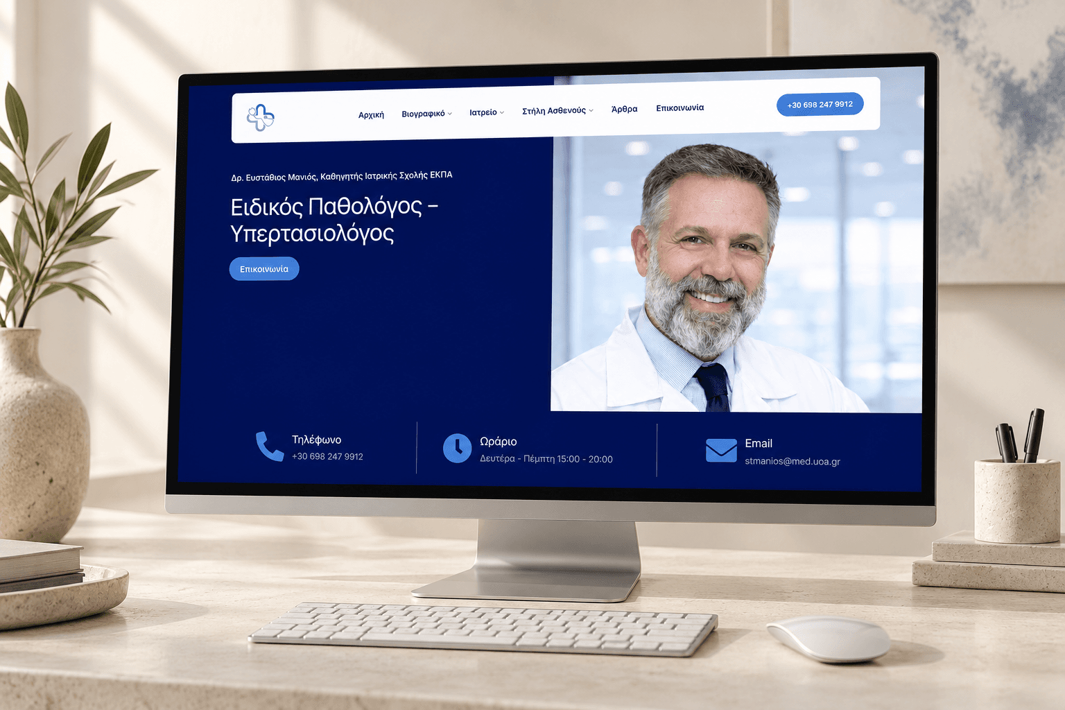 The Efstathios Manios homepage on a large desktop display in a bright studio